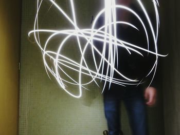 Close-up of man holding illuminated electric lamp at night