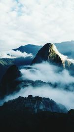 Scenic view of snowcapped mountains against cloudy sky