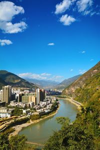 River amidst buildings against blue sky