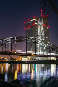 Illuminated bridge over river at night
