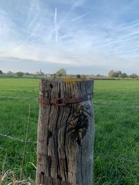 Wooden posts on field against sky