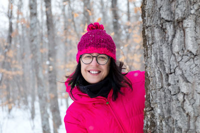 Portrait of smiling woman in snow covered tree