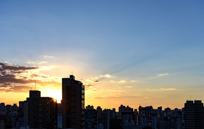 Silhouette buildings against sky during sunset