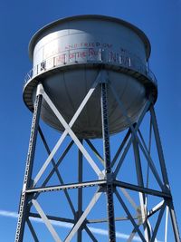 Low angle view of water tower against clear blue sky