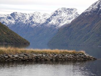 Scenic view of lake and snowcapped mountains against sky