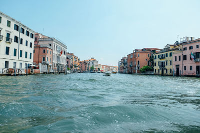 View of buildings by sea against clear sky