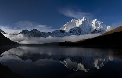 Scenic view of lake and snowcapped mountains against sky