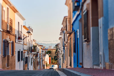 Street amidst buildings in town against sky