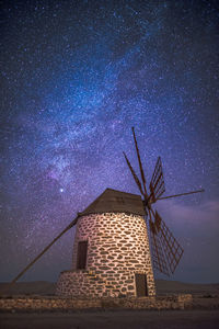 Traditional windmill against sky at night