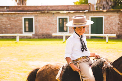 Portrait of boy sitting over horse