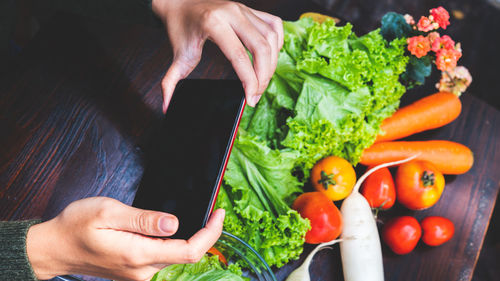 Midsection of man holding vegetables