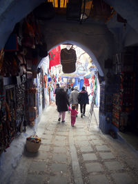 Rear view of people walking in tunnel