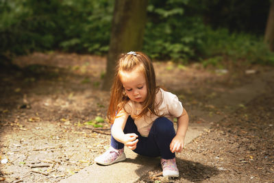 Portrait of cute girl sitting on field