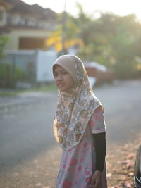 Girl wearing hijab standing on road