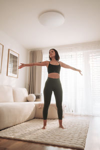 Full length of woman exercising at home