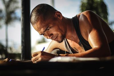 Portrait of young man reading book on table