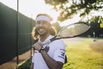 Portrait of smiling man holding tennis racket