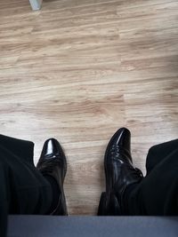 Low section of person standing on hardwood floor