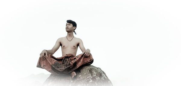 Low angle view of shirtless man against white background