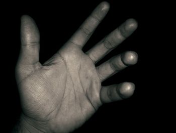 Close-up of human hand over black background