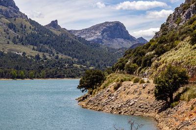 Scenic view of lake by mountains against sky