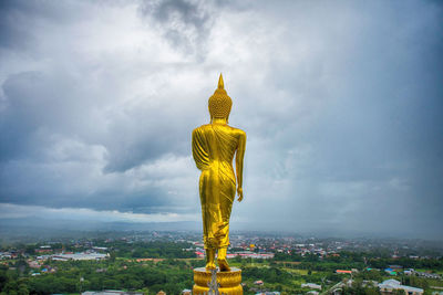 Buddha statue against cloudy sky
