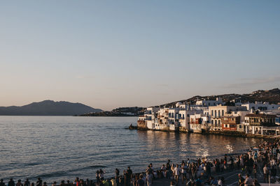 People watching sunset over the old houses in little venice, hora-mykonos town , mykonos, greece.