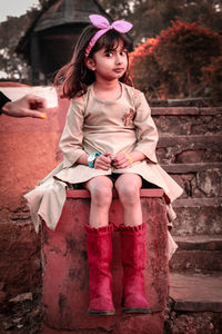 Portrait of cute girl sitting outdoors