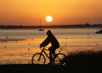 Silhouette of boy on beach at sunset