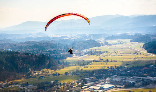 Person paragliding over village