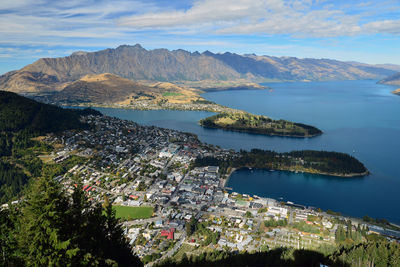 Aerial view of city by sea against sky