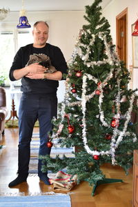Full length of man with christmas tree