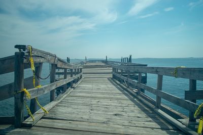 Pier over sea against sky during sunny day