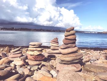 Stack of stones on beach against sky