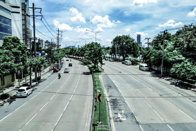 View of city street against cloudy sky