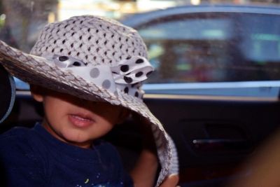 Close-up of boy wearing hat in car