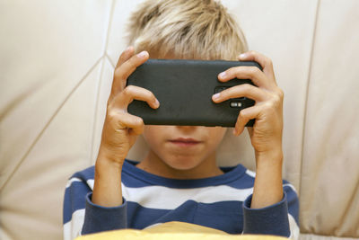 Portrait of boy holding mobile phone