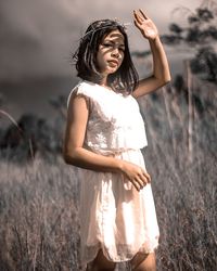 Portrait of young woman standing on field