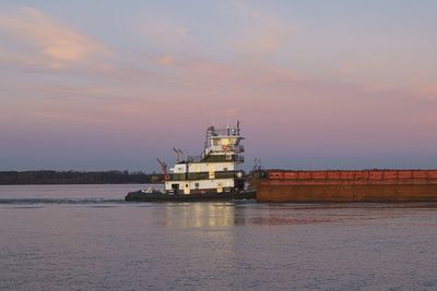 A push boat moving barges up the tennessee river on a december afternoon just before sunset.