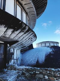 Low angle view of abandoned building against sky during winter