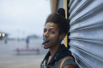 Young man sticking out his blue tongue