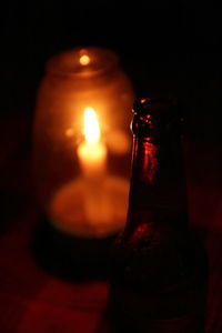Close-up of lit candle in dark room