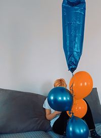 Low angle view of balloons against wall at home