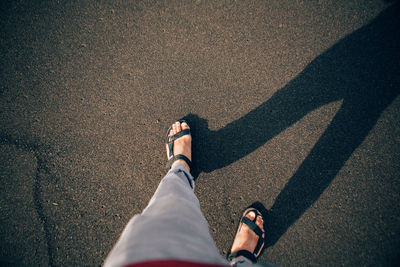 Low section of man walking on road