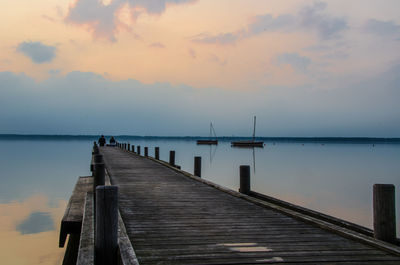 Jetty over lake against sky during sunset