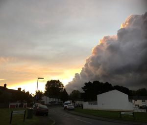 Cars on road against sky during sunset