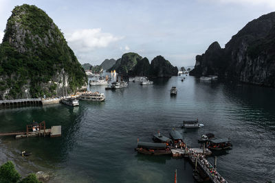 High angle view of boats on sea amidst rock formations against sky