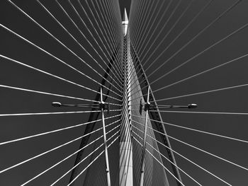 Low angle view of suspension bridge cables against sky