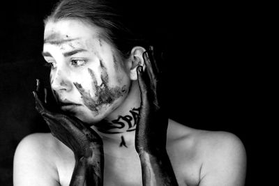 Close-up of young woman on black background