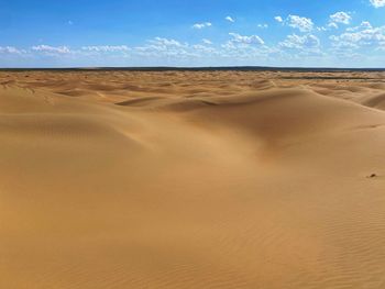 Sand dunes in desert against sky